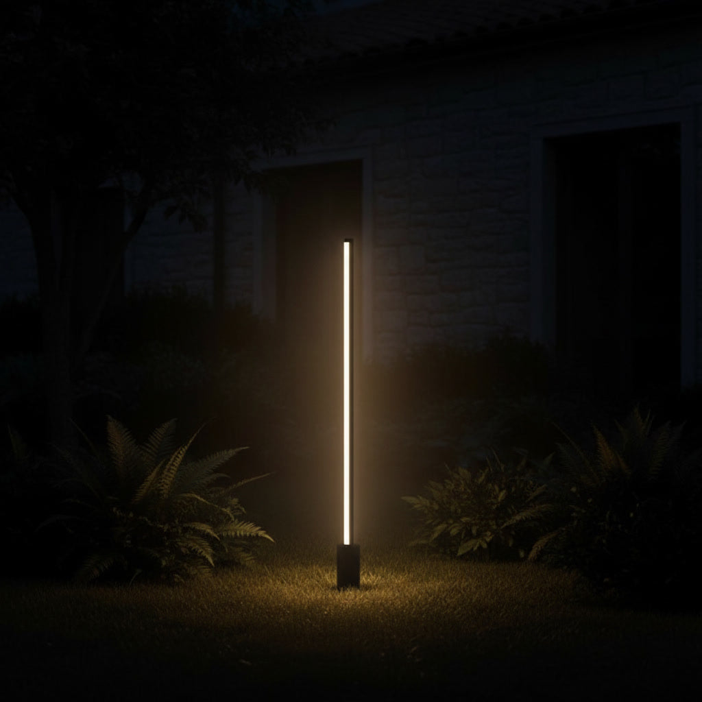 Lumira Bollard Light glowing at night in a garden